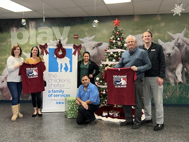 Quality Fasteners staff and The Children's Shelter team holding Washers for a Cause tournament shirts at the shelter.